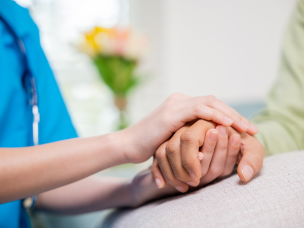 A nurse holding someone's hand